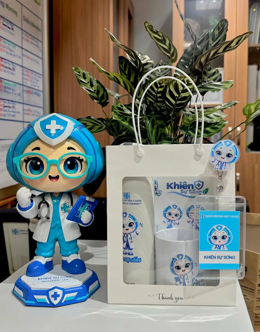 Mô hình linh vật “Khiên Sự Sống” đặt cạnh bộ quà tặng cùng nhận diện.
